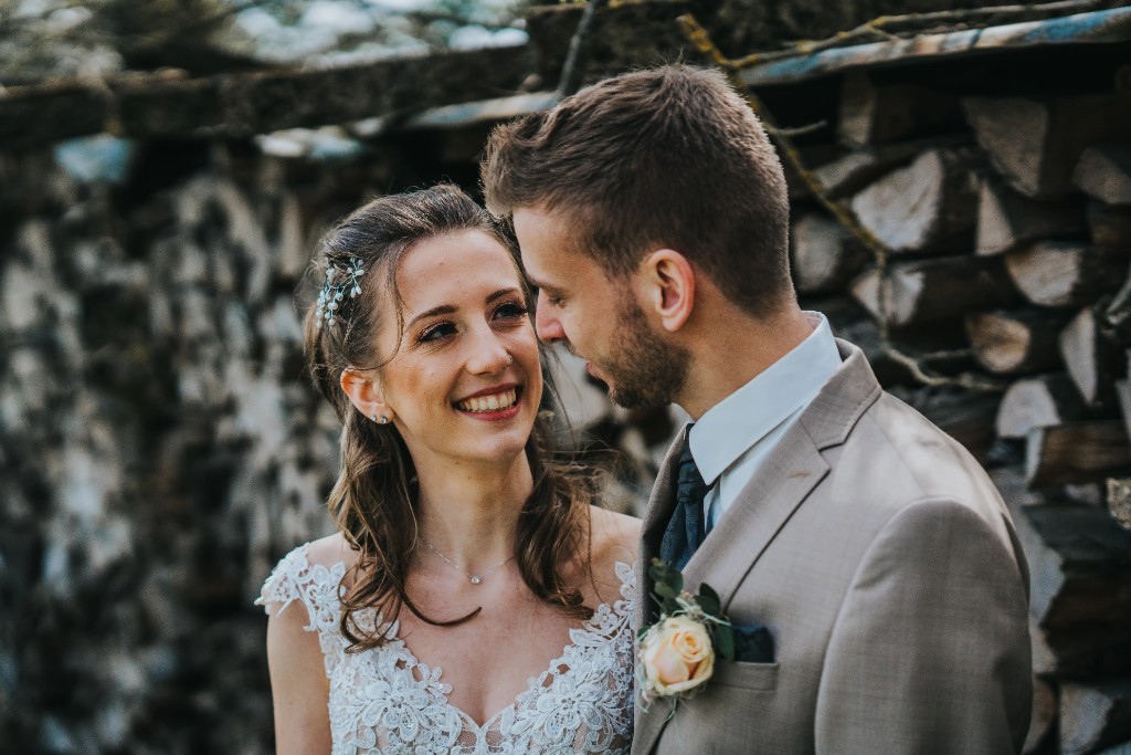 Joyful wedding couple portrait against rustic wood background by Swiss privacy-first photographer